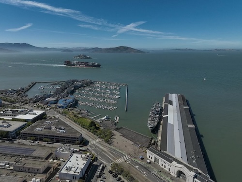 Aerial view of San Francisco's working waterfront, Pier 45 and the marina, with a container ship on the bay.